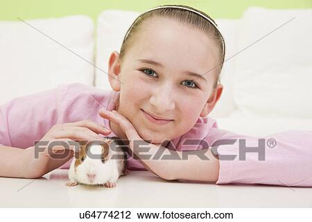 Stock Image - USA, Illinois, Metamora, Portrait of girl (10-11) with guinea pig. Fotosearch