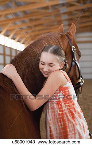 Stock Image - USA, Illinois, Metamora, Portrait of girl (10-11) embracing horse. Fotosearch