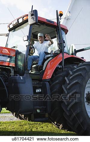 USA, Illinois, Metamora, Portrait of farmer driving tractor View Large Photo Image Stock Image - USA, Illinois, Metamora, Portrait of farmer driving tractor. Fotosearch