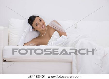 Stock Image - USA, Illinois, Metamora, Portrait of bride relaxing on sofa. Fotosearch
