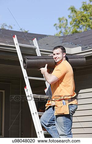 Stock Image - USA, Illinois, Metamora, Portrait of worker standing on ladder. Fotosearch