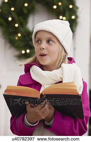 Stock Photo - USA, Illinois, Metamora, Portrait of girl (6-7) singing carols. Fotosearch