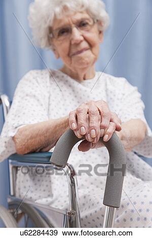 Stock Photo - USA, Illinois, Metamora, Portrait of senior woman sitting on wheelchair and holding cane. Fotosearch