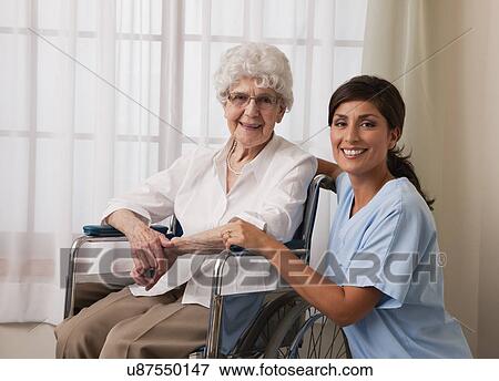 Stock Photo - USA, Illinois, Metamora, Portrait of female nurse and senior woman on wheelchair. Fotosearch