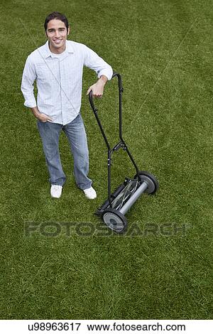 USA, Illinois, Metamora, Portrait of young man with lawnmower View Large Photo Image Stock Photo - USA, Illinois, Metamora, Portrait of young man with lawnmower. Fotosearch