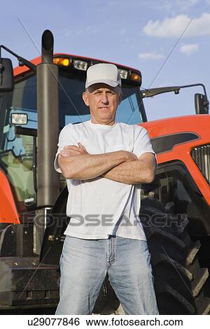 USA, Illinois, Metamora, Portrait of farmer by tractor View Large Photo Image Stock Photograph - USA, Illinois, Metamora, Portrait of farmer by tractor. Fotosearch