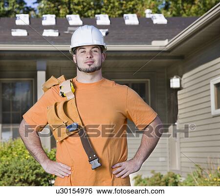 Stock Photograph - USA, Illinois, Metamora, Portrait of young worker with tool belt. Fotosearch
