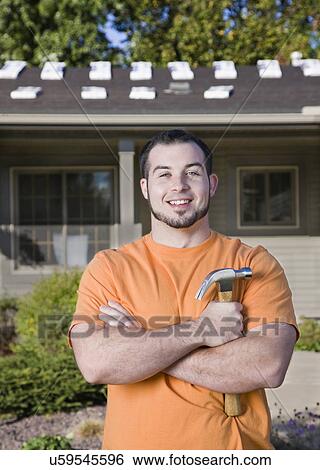 Stock Photograph - USA, Illinois, Metamora, Portrait of young worker holding hammer. Fotosearch