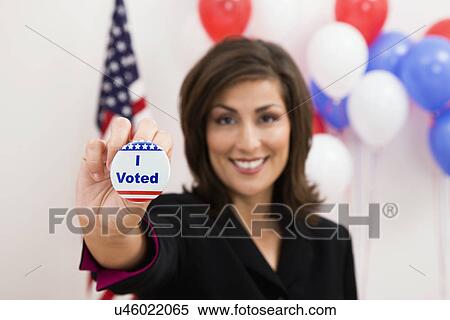 USA, Illinois, Metamora, Portrait of smiling woman holding vote button, US flag and balloons in background View Large Photo Image Stock Photography - USA, Illinois, Metamora, Portrait of smiling woman holding vote button, US flag and balloons in background. Fotosearch