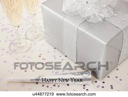 Stock Photo - USA, Illinois, Metamora, Present, champagne flutes and party blower. Fotosearch