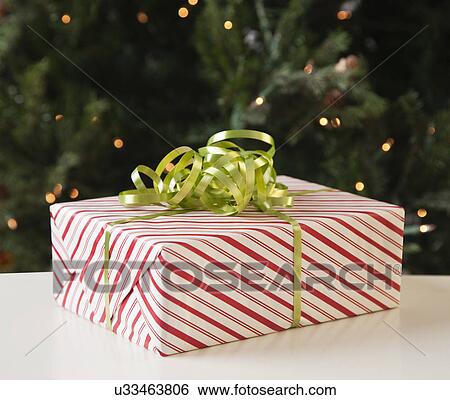Stock Photograph - USA, Illinois, Metamora, Present with Christmas tree in background. Fotosearch