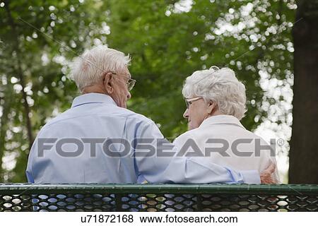 USA, Illinois, Metamora, Rear view of senior couple in sitting on bench park View Large Photo Image Stock Photo - USA, Illinois, Metamora, Rear view of senior couple in sitting on bench park. Fotosearch