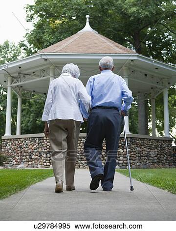 USA, Illinois, Metamora, Rear view of senior couple walking in park View Large Photo Image Stock Photography - USA, Illinois, Metamora, Rear view of senior couple walking in park. Fotosearch