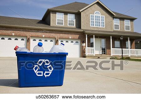 Stock Photo - USA, Illinois, Metamora, Recycling bin in front of house. Fotosearch