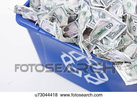 Stock Photo - USA, Illinois, Metamora, Recycling bin full of US money. Fotosearch