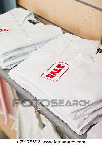 USA, Illinois, Metamora, Sale tag on folded shirts in shop View Large Photo Image Stock Image - USA, Illinois, Metamora, Sale tag on folded shirts in shop. Fotosearch