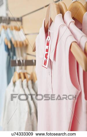 USA, Illinois, Metamora, Sale tag on clothing hanging on rail in shop View Large Photo Image Stock Photo - USA, Illinois, Metamora, Sale tag on clothing hanging on rail in shop. Fotosearch
