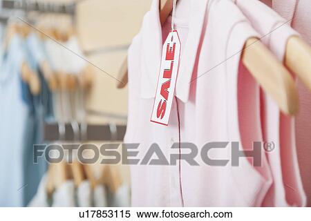 Stock Photography - USA, Illinois, Metamora, Sale tag on clothing hanging on rail in shop. Fotosearch