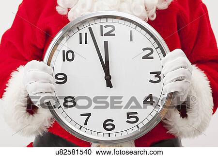 Stock Image - USA, Illinois, Metamora, Santa claus holding large clock. Fotosearch