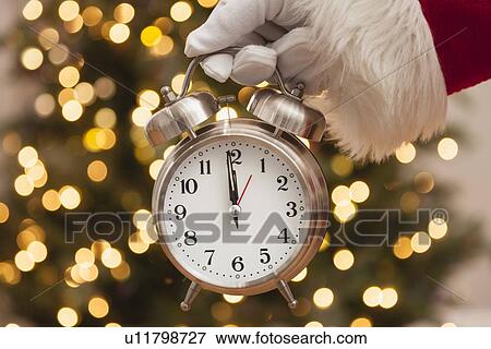 Stock Photo - USA, Illinois, Metamora, Santa claus holding alarm clock. Fotosearch
