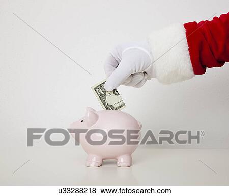 USA, Illinois, Metamora, Santa claus putting banknote into piggy bank View Large Photo Image Stock Photo - USA, Illinois, Metamora, Santa claus putting banknote into piggy bank. Fotosearch