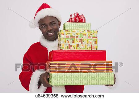 Stock Photo - USA, Illinois, Metamora, Santa Claus holding stack of Christmas presents. Fotosearch
