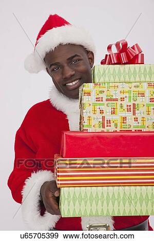 USA, Illinois, Metamora, Santa Claus holding stack of Christmas presents View Large Photo Image Stock Photo - USA, Illinois, Metamora, Santa Claus holding stack of Christmas presents. Fotosearch