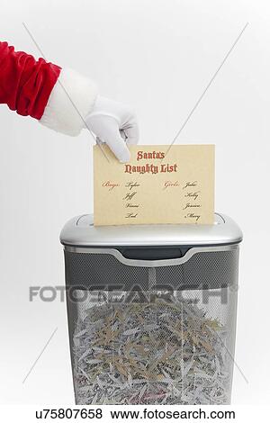Stock Photo - USA, Illinois, Metamora, Santa claus shredding santa's naughty list. Fotosearch