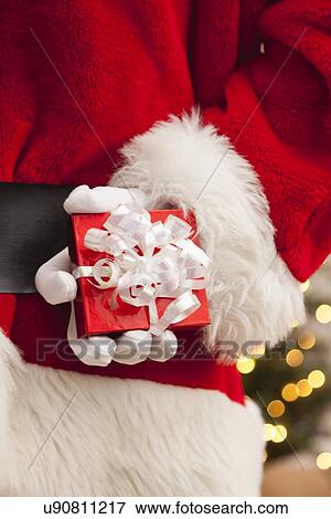 Stock Photo - USA, Illinois, Metamora, Santa claus holding small gift. Fotosearch