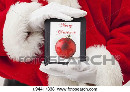 USA, Illinois, Metamora, Santa claus holding digital tablet with christmas decoration on screen View Large Photo Image Stock Photo - USA, Illinois, Metamora, Santa claus holding digital tablet with christmas decoration on screen. Fotosearch