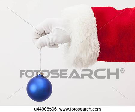 Stock Photograph - USA, Illinois, Metamora, Santa claus holding christmas ornament. Fotosearch