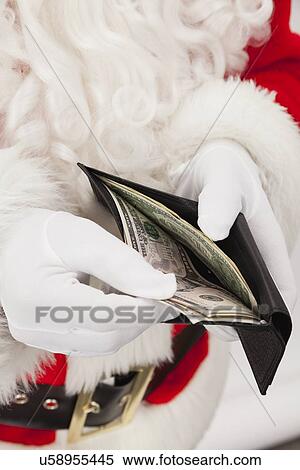 Stock Photography - USA, Illinois, Metamora, Santa claus counting money in wallet. Fotosearch