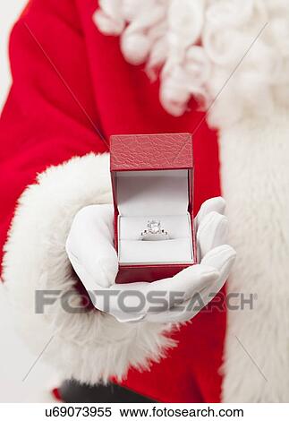 Stock Photography - USA, Illinois, Metamora, Santa claus holding ring in jewelry box. Fotosearch