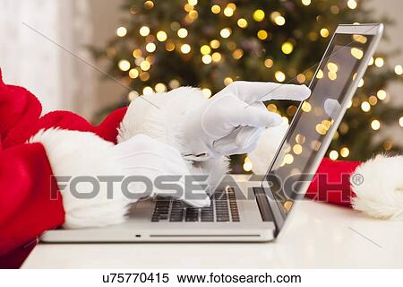 Stock Photography - USA, Illinois, Metamora, Santa claus shopping with laptop. Fotosearch