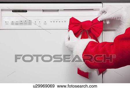 USA, Illinois, Metamora, Santa clause putting bow on dishwasher View Large Photo Image Stock Photo - USA, Illinois, Metamora, Santa clause putting bow on dishwasher. Fotosearch