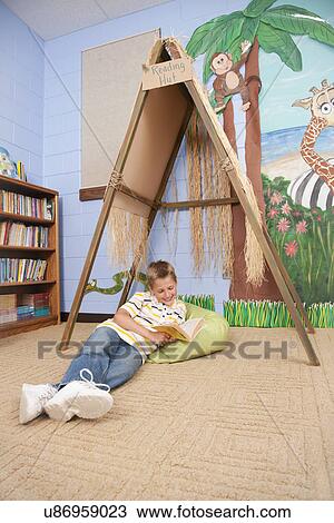USA, Illinois, Metamora, School boy (8-9) reading on floor in school View Large Photo Image Stock Image - USA, Illinois, Metamora, School boy (8-9) reading on floor in school. Fotosearch