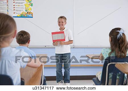 USA, Illinois, Metamora, School boy presenting work to class (8-9) in classroom View Large Photo Image Stock Photo - USA, Illinois, Metamora, School boy presenting work to class (8-9) in classroom. Fotosearch