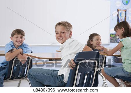 Stock Photograph - USA, Illinois, Metamora, School children (8-9) smiling in classroom. Fotosearch