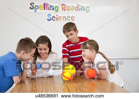 Stock Image - USA, Illinois, Metamora, Schoolchildren (8-9, 10-11) with solar system model at science class. Fotosearch