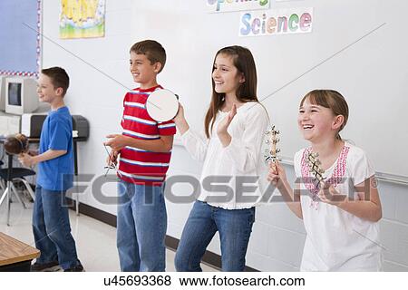 Stock Photo - USA, Illinois, Metamora, Schoolchildren (8-9, 10-11) playing music in classroom. Fotosearch