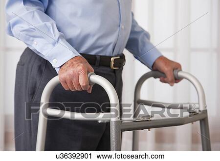 Stock Image - USA, Illinois, Metamora, Senior man walking with walker, mid section. Fotosearch