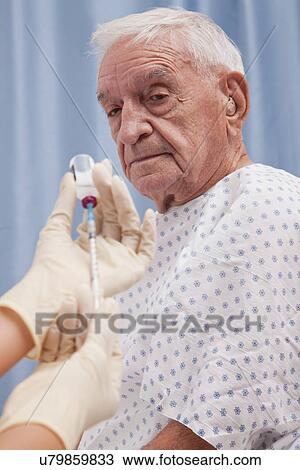 USA, Illinois, Metamora, Senior man looking at doctor's hands holding syringe View Large Photo Image Stock Image - USA, Illinois, Metamora, Senior man looking at doctor's hands holding syringe. Fotosearch