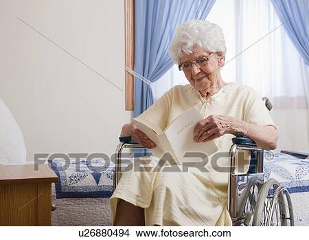 USA, Illinois, Metamora, Senior woman on wheelchair reading Bible View Large Photo Image Picture - USA, Illinois, Metamora, Senior woman on wheelchair reading Bible. Fotosearch