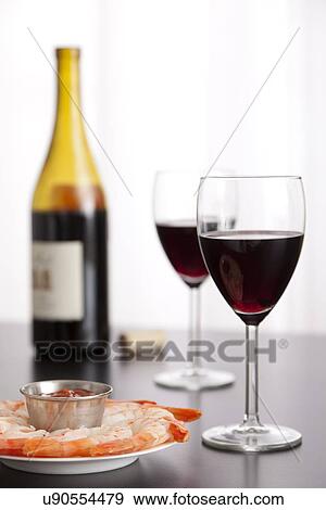 Stock Photo - USA, Illinois, Metamora, Shrimps on plate and wineglasses. Fotosearch