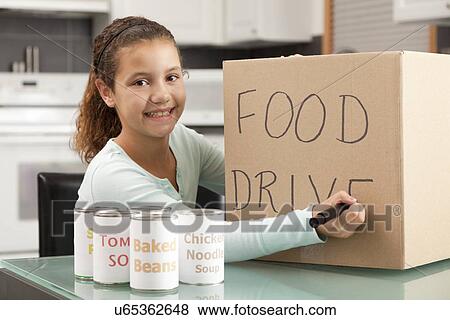 Stock Photo - USA, Illinois, Metamora, Smiling girl (10-11) preparing food drive in kitchen. Fotosearch