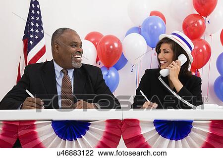 USA, Illinois, Metamora, Smiling man and woman at polling place table, red and blue balloons in background View Large Photo Image Stock Image - USA, Illinois, Metamora, Smiling man and woman at polling place table, red and blue balloons in background. Fotosearch