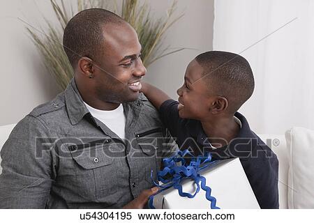 USA, Illinois, Metamora, Son (6-7) giving present to his father View Large Photo Image Stock Photography - USA, Illinois, Metamora, Son (6-7) giving present to his father. Fotosearch