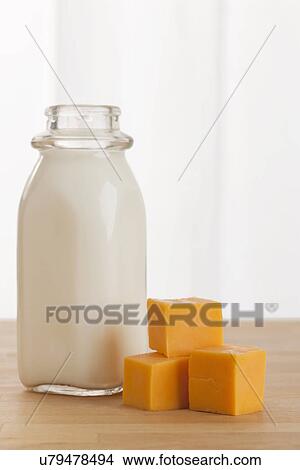 Picture - USA, Illinois, Metamora, Stacked cheese beside bottle of milk. Fotosearch