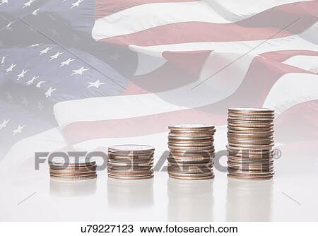 Stock Image - USA, Illinois, Metamora, Stacks of US coins in front of US flag. Fotosearch