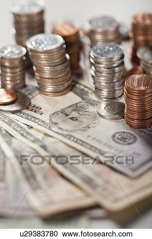 Stock Image - USA, Illinois, Metamora, Studio shot of American banknotes and stacks of coins. Fotosearch